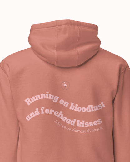 Back view of a Dusty Rose hoodie featuring the phrase "Running on bloodlust and forehead kisses" on the back. Perfect for fans of funny merchandise, bold humor, and witty sarcasm.