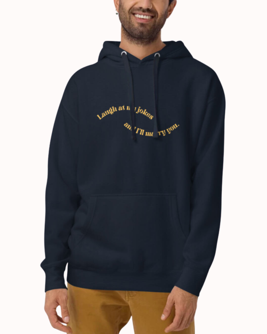 Front view of a navy blazer hoodie worn by a smiling man, featuring the phrase 'Laugh at my jokes and I'll marry you' on the chest. Perfect for fans of funny merchandise, bold humor, and witty sarcasm.