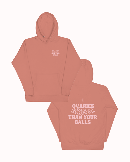 Front and back view of a dusty rose hoodie featuring the phrase 'Ovaries bigger than your balls' on the back. Perfect for fans of funny merchandise, bold humor, and witty sarcasm.