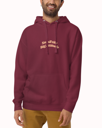 Front view of a Maroon hoodie worn by a smiling man, featuring the phrase "Small tits. Big attitude" on the chest and back. Perfect for fans of funny merchandise, bold humor, and witty sarcasm.