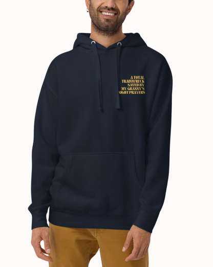 Front view of a Navy Blazer hoodie worn by a smiling man, featuring the phrase "A total trainwreck saved my granny's night prayers" on the chest and back. Perfect for fans of funny merchandise, bold humor, and witty sarcasm.