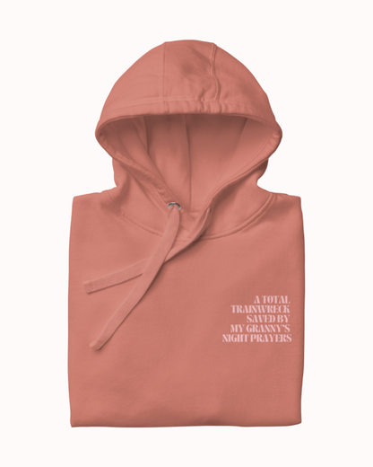 Back view of a Dusty Rose hoodie featuring the phrase "A total trainwreck saved my granny's night prayers" on the back. Perfect for fans of funny merchandise, bold humor, and witty sarcasm.